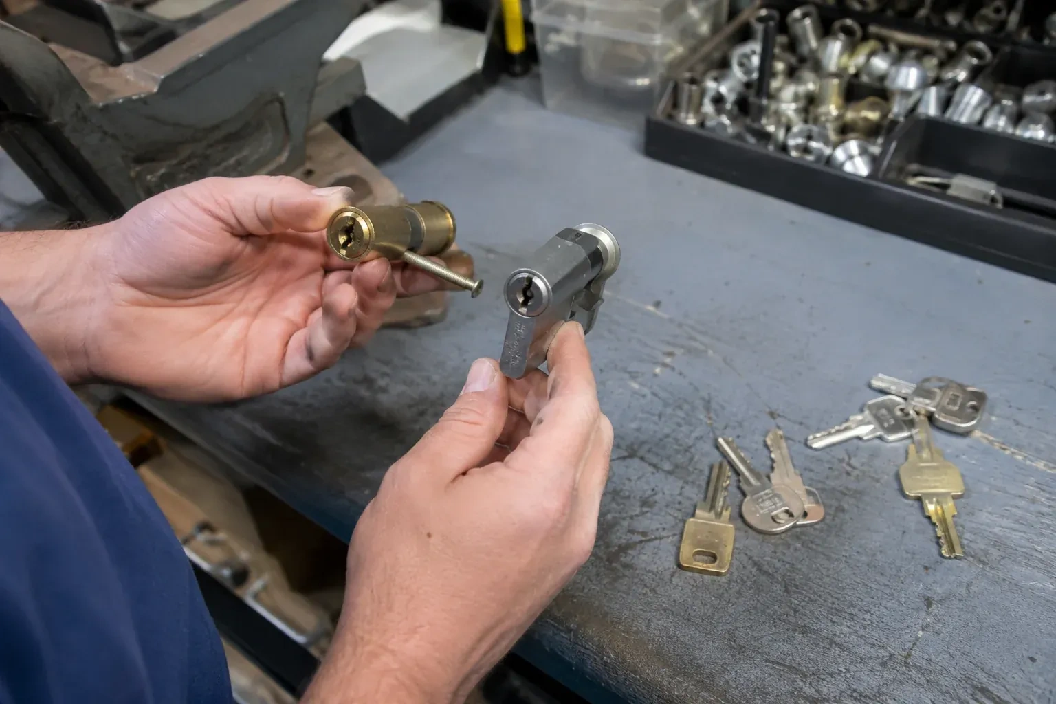 Hands comparing detached lock cylinders beside loose keys on a workbench. — Broken Key Extraction, Port Colborne